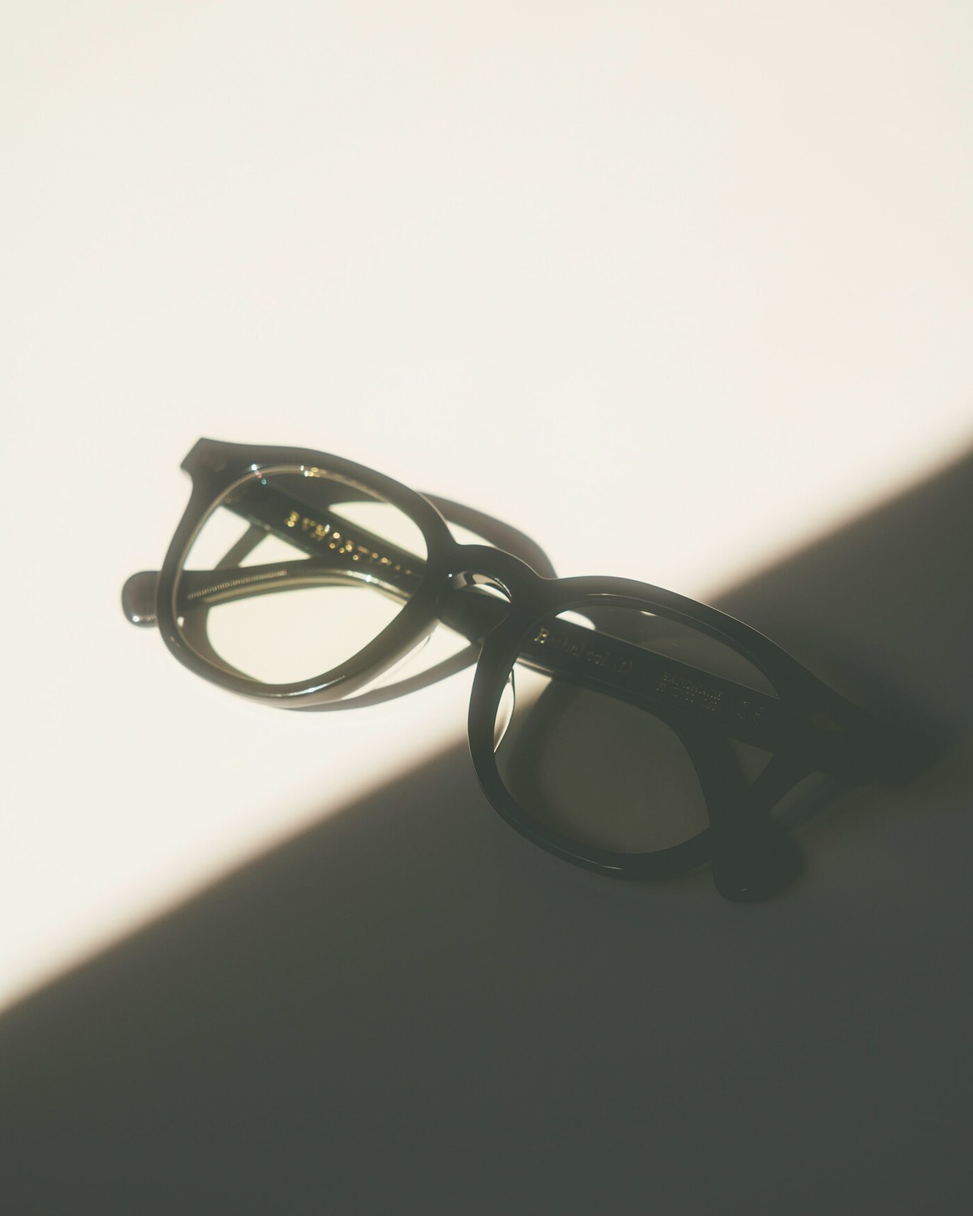 A pair of glasses in soft, directional light.